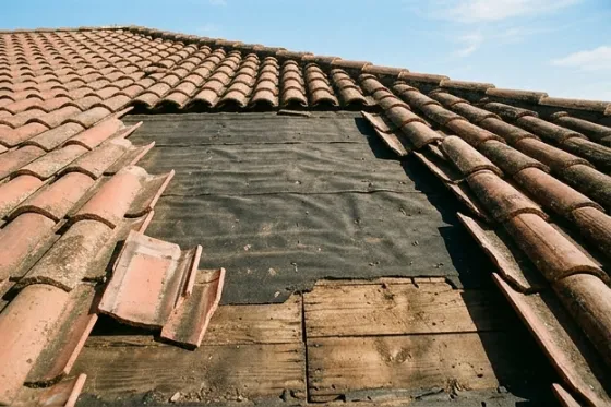 Tiles removed to show the felt underlayment laid over the wood deck beneath